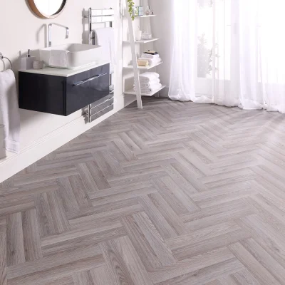 Bright minimalist bathroom with light-hued herringbone floor, white vanity with black drawer, vessel sink, chrome faucet, open towel shelves, and sheer curtains.