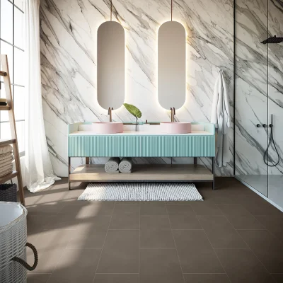 Modern bathroom with marble walls, oval mirrors above a mint-green ribbed vanity with two pink basins, towels on a lower shelf, and a glass shower.