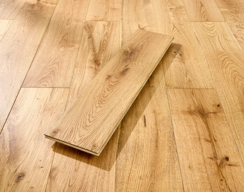 Light wooden floor with a single plank propped diagonally across the boards, showing natural grain and knots.